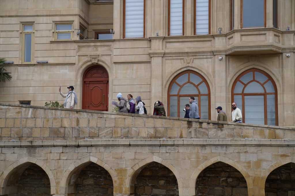 Tourists walking along a stone walkway of a historic building. Capturing memories and experiences.