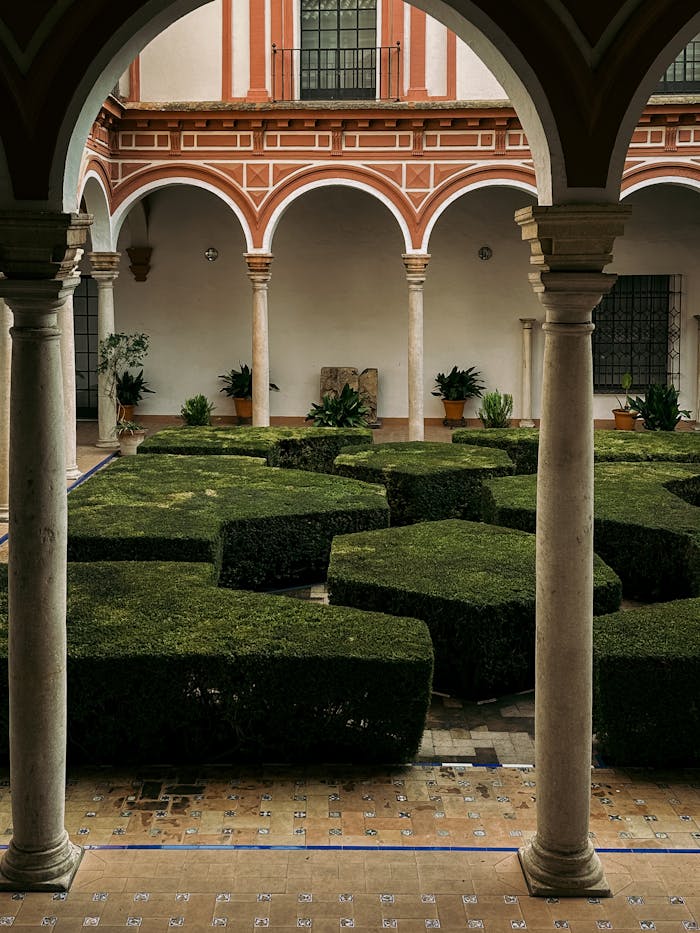 Beautifully manicured courtyard garden in a historic building in Seville, Spain.